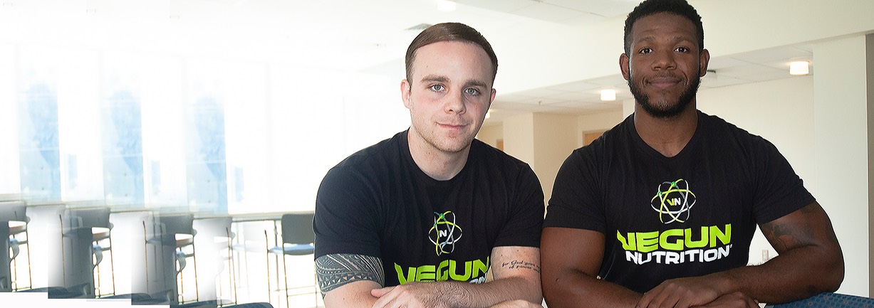 Two former students wearing Vegun Nutrition shirts