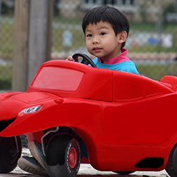 boy in red toy car